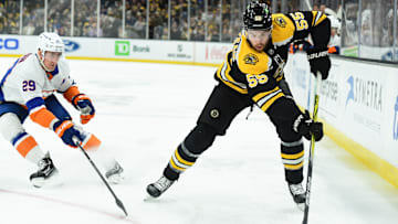 Jan 5, 2025; Boston, Massachusetts, USA; Boston Bruins right wing Justin Brazeau (55) controls the puck while New York Islanders center Brock Nelson (29) defends during the first period at TD Garden. Mandatory Credit: Bob DeChiara-Imagn Images