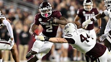 Nov 11, 2023; College Station, Texas, USA; Texas A&M Aggies running back Rueben Owens (2) runs the ball during the second half as Mississippi State Bulldogs linebacker Jett Johnson (44) defends at Kyle Field. Mandatory Credit: Maria Lysaker-Imagn Images
