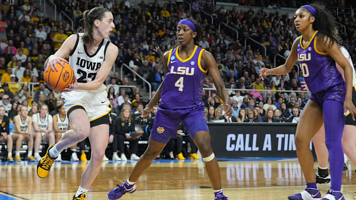 Apr 1, 2024; Albany, NY, USA; Iowa Hawkeyes guard Caitlin Clark (22) controls the ball against LSU Lady Tigers guard Flau'jae Johnson (4) and LSU Lady Tigers forward Angel Reese (10) in the third quarter in the finals of the Albany Regional in the 2024 NCAA Tournament at MVP Arena. Mandatory Credit: Gregory Fisher-Imagn Images
