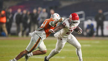 Dec 28, 2023; Bronx, NY, USA; Rutgers Scarlet Knights running back Samuel Brown V (27) fights off a tackle by Miami Hurricanes linebacker Francisco Mauigoa (51) during the fourth quarter at Yankee Stadium. Mandatory Credit: Mark Smith-USA TODAY Sports
