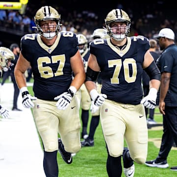 Aug 25, 2024; New Orleans, Louisiana, USA;  New Orleans Saints offensive tackle Trevor Penning (70) and offensive tackle Landon Young (67) during the warmups before the game against the Tennessee Titans at Caesars Superdome. Mandatory Credit: Stephen Lew-Imagn Images