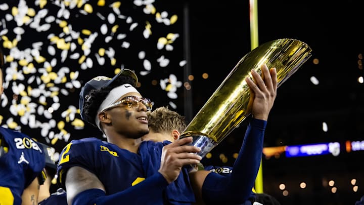 Jan 8, 2024; Houston, TX, USA; Michigan Wolverines defensive back Will Johnson (2) celebrates with the championship trophy after defeating the Washington Huskies during the 2024 College Football Playoff national championship game at NRG Stadium. Mandatory Credit: Mark J. Rebilas-Imagn Images