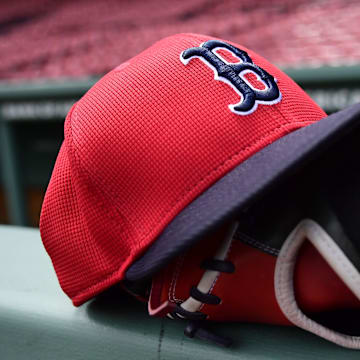 May 18, 2025; Boston, Massachusetts, USA;  A Boston Red Sox hat and glove rests on the railing by the dugout prior to a game against the Atlanta Braves at Fenway Park. Mandatory Credit: Bob DeChiara-Imagn Images