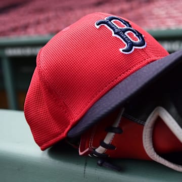 May 18, 2025; Boston, Massachusetts, USA;  A Boston Red Sox hat and glove rests on the railing by the dugout prior to a game against the Atlanta Braves at Fenway Park. Mandatory Credit: Bob DeChiara-Imagn Images