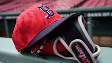 May 18, 2025; Boston, Massachusetts, USA;  A Boston Red Sox hat and glove rests on the railing by the dugout prior to a game against the Atlanta Braves at Fenway Park. Mandatory Credit: Bob DeChiara-Imagn Images