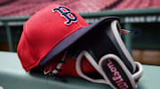 May 18, 2025; Boston, Massachusetts, USA;  A Boston Red Sox hat and glove rests on the railing by the dugout prior to a game against the Atlanta Braves at Fenway Park. Mandatory Credit: Bob DeChiara-Imagn Images
