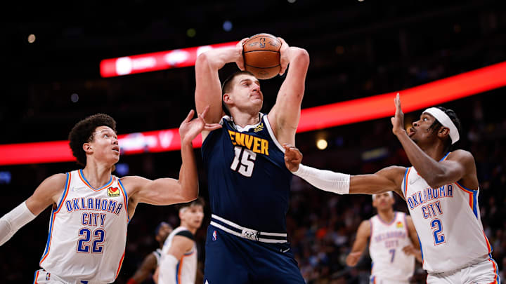 Mar 2, 2022; Denver, Colorado, USA; Denver Nuggets center Nikola Jokic (15) controls the ball as Oklahoma City Thunder forward Isaiah Roby (22) and guard Shai Gilgeous-Alexander (2) guard in the second quarter at Ball Arena. Mandatory Credit: Isaiah J. Downing-Imagn Images