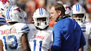Nov 23, 2024; Charlottesville, Virginia, USA; Southern Methodist Mustangs head coach Rhett Lashlee (center) huddles with players during a stoppage in play in the first half against the Virginia Cavaliers at Scott Stadium. Mandatory Credit: Amber Searls-Imagn Images