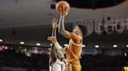 Jan 15, 2025; Norman, Oklahoma, USA; Texas Longhorns guard Jordan Pope (0) shoots beside Oklahoma Sooners guard Kobe Elvis (1) during the first half at Lloyd Noble Center. Mandatory Credit: Alonzo Adams-Imagn Images