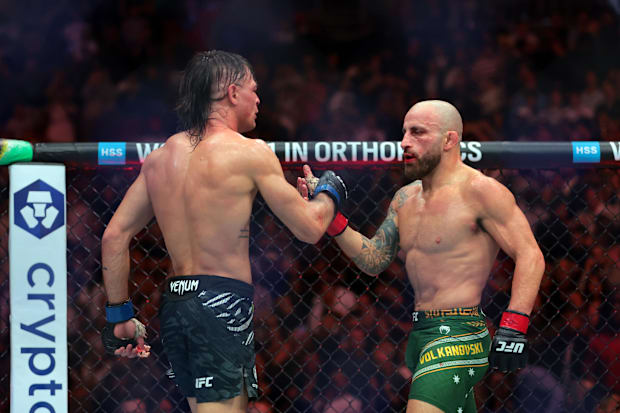 Alexander Volkanovski (red gloves) shake hands with Diego Lopes (blue gloves) during UFC 314 at Kaseya Center.