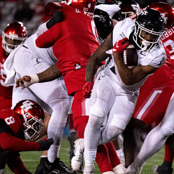 Cincinnati Bearcats running back Corey Kiner (21) runs for a touchdown as Houston Cougars linebacker Treylin Payne (29) and Houston Cougars defensive back Juwon Gaston (21) attempt to stop him in the fourth quarter of the NCAA football game between the Cincinnati Bearcats and the Houston Cougars TDECU Stadium in Houston, Texas, on Saturday, Nov. 11, 2023.