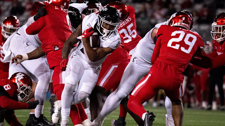 Cincinnati Bearcats running back Corey Kiner (21) runs for a touchdown as Houston Cougars linebacker Treylin Payne (29) and Houston Cougars defensive back Juwon Gaston (21) attempt to stop him in the fourth quarter of the NCAA football game between the Cincinnati Bearcats and the Houston Cougars TDECU Stadium in Houston, Texas, on Saturday, Nov. 11, 2023.