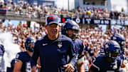 Aug 30, 2025; East Hartford, Connecticut, USA; Connecticut Huskies head coach Jim Mora runs onto the field before the start of the game against the Central Connecticut State Blue Devils at Pratt & Whitney Stadium at Rentschler Field. Mandatory Credit: David Butler II-Imagn Images
