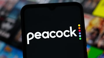 The Peacock logo is seen on a phone screen.