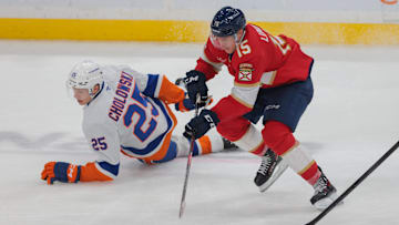 Feb 2, 2025; Sunrise, Florida, USA; Florida Panthers center Anton Lundell (15) moves the puck past New York Islanders defenseman Dennis Cholowski (25) during the third period at Amerant Bank Arena. Mandatory Credit: Sam Navarro-Imagn Images
