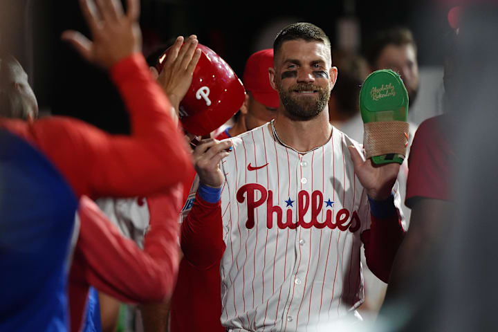 Philadelphia Phillies infielder Bryce Harper celebrates with teammates after scoring a run against the Boston Red Sox.