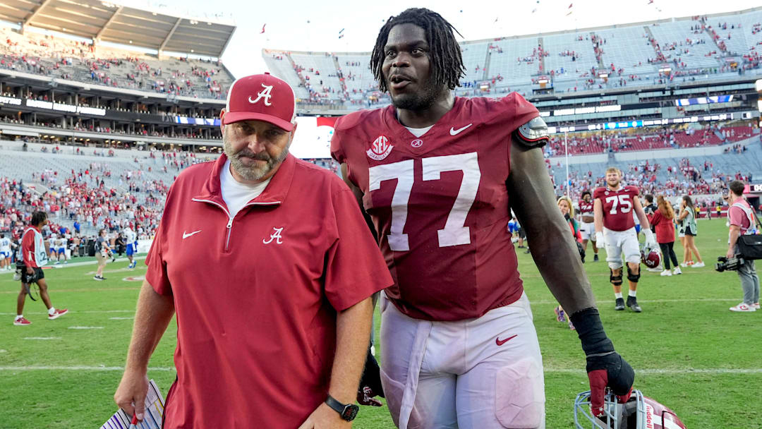 Nov 22, 2025; Tuscaloosa, Alabama, USA; Offensive line coach Chris Kapilovic walks of the field with Alabama senior offensive lineman Jaeden Roberts (77) at Saban Field at Bryant-Denny Stadium. Mandatory Credit: Gary Cosby Jr.-Imagn Images