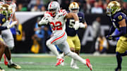 Jan 20, 2025; Atlanta, GA, USA; Ohio State Buckeyes running back TreVeyon Henderson (32) runs with the ball against the Notre Dame Fighting Irish during the first half the CFP National Championship college football game at Mercedes-Benz Stadium. Mandatory Credit: Mark J. Rebilas-Imagn Images