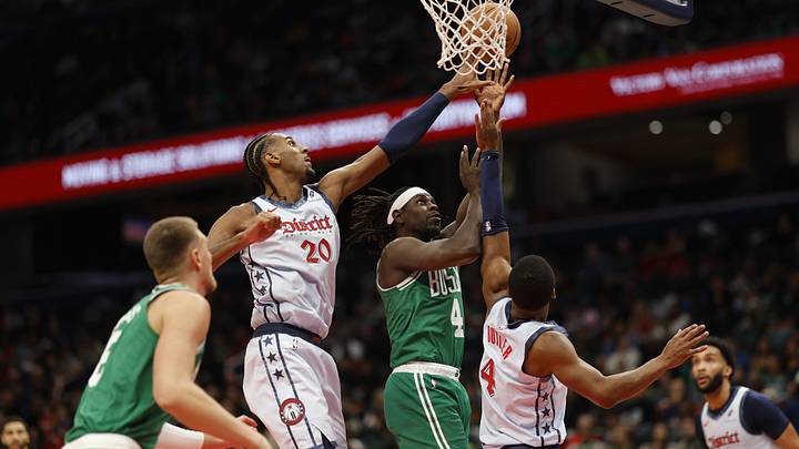 Dec 15, 2024; Washington, District of Columbia, USA; Boston Celtics guard Jrue Holiday (4) shoots the ball as Washington Wizards forward Alexandre Sarr (20) and Wizards guard Jared Butler (4) defended in the second quarter at Capital One Arena. Mandatory Credit: Geoff Burke-Imagn Images