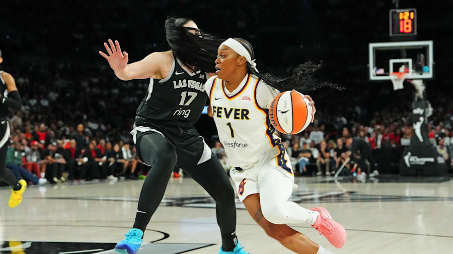 Fever guard Odyssey Sims (1) dribbles around Las Vegas Aces center Megan Gustafson (
