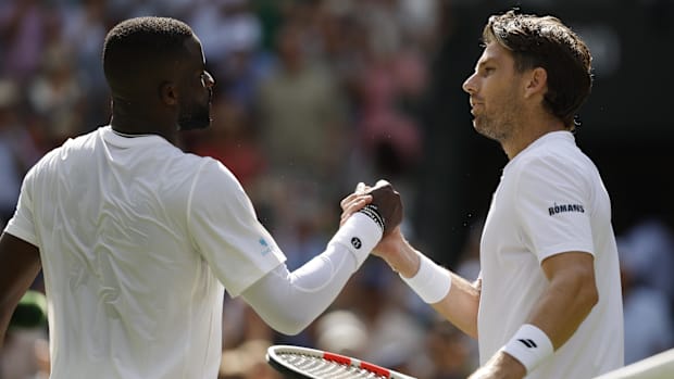 Jul 2, 2025; Wimbledon, United Kingdom; Cameron Norrie (GBR)(R) shakes hands with Frances Tiafoe (USA)(L) at the net after th