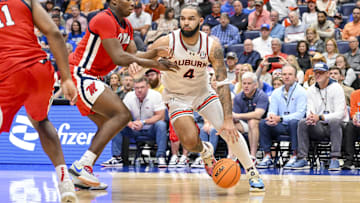 Mar 14, 2025; Nashville, TN, USA;  Auburn Tigers forward Johni Broome (4) dribbles past Mississippi Rebels forward Malik Dia (0) during the first half at Bridgestone Arena. Mandatory Credit: Steve Roberts-Imagn Images