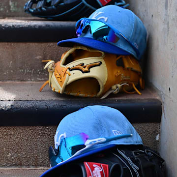 Mar 12, 2024; Salt River Pima-Maricopa, Arizona, USA;  General view of Kansas City Royals hats and gloves in the first inning against the Colorado Rockies during a spring training game at Salt River Fields at Talking Stick. Mandatory Credit: Matt Kartozian-Imagn Images