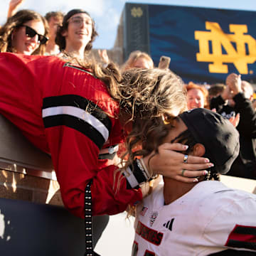 Northern Illinois linebacker Jaden Dolphin kisses his girlfriend Ruby Mendez Toomey after winning a NCAA college football game 16-14 against Notre Dame at Notre Dame Stadium on Saturday, Sept. 7, 2024, in South Bend.