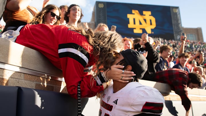 Northern Illinois linebacker Jaden Dolphin kisses his girlfriend Ruby Mendez Toomey after winning a NCAA college football game 16-14 against Notre Dame at Notre Dame Stadium on Saturday, Sept. 7, 2024, in South Bend.