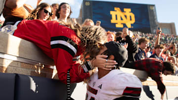 Northern Illinois linebacker Jaden Dolphin kisses his girlfriend Ruby Mendez Toomey after winning a NCAA college football game 16-14 against Notre Dame at Notre Dame Stadium on Saturday, Sept. 7, 2024, in South Bend.