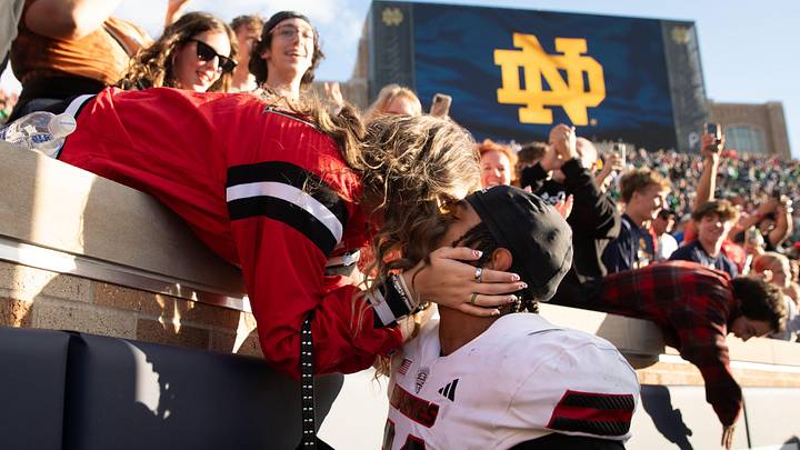 Northern Illinois linebacker Jaden Dolphin kisses his girlfriend Ruby Mendez Toomey after winning a NCAA college football game 16-14 against Notre Dame at Notre Dame Stadium on Saturday, Sept. 7, 2024, in South Bend.