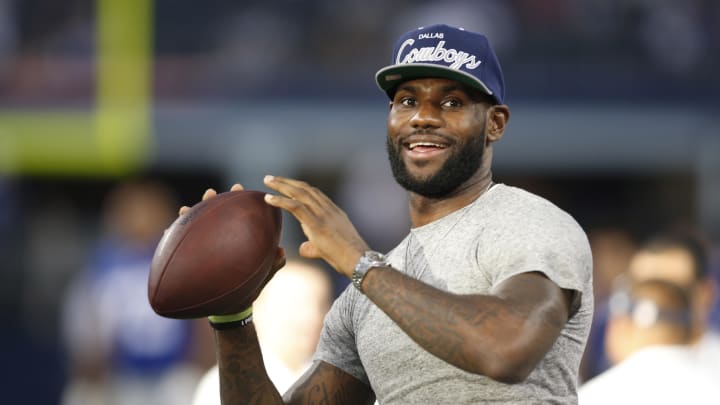 Sep 8, 2013; Arlington, TX, USA; Miami Heat guard LeBron James throws a football on the sidelines of the game  between the Dallas Cowboys and the New York Giants at AT&T Stadium. Mandatory Credit: Tim Heitman-USA TODAY Sports