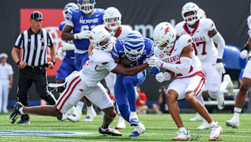 Sep 20, 2025; Memphis, Tennessee, USA; Memphis Tigers running back Greg Desrosiers Jr. (13) is tackled by Arkansas Razorbacks defensive back Larry Worth III (3) and defensive back Julian Neal (23) during the first half at Simmons Bank Liberty Stadium. Mandatory Credit: Wesley Hale-Imagn Images