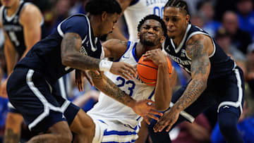 Oct 30, 2025; Lexington, KY, USA; Kentucky Wildcats forward Mouhamed Dioubate (23) holds onto the ball against Georgetown Hoyas guards Kj Lewis (left) and Deshawn Harris-Smith (right) during the first half at Rupp Arena at Central Bank Center. Mandatory Credit: Jordan Prather-Imagn Images