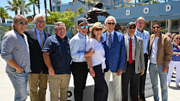 Los Angeles Dodgers owners Todd Boehly, Mark Walter, Robert Patton Jr., Stan Kasten, Helen Weisz Kasten with Sandy Koufax along with owners Peter Gruber, Robert L. Plummer, and Alan Smolinisky in front of the brand new Koufax commemorative statue during an unveiling ceremony at the Centerfield Plaza at Dodger Stadium on June 18, 2022.