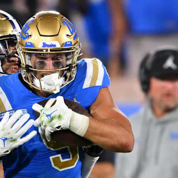 Sep 30, 2022; Pasadena, California, USA; UCLA Bruins wide receiver Jake Bobo (9) runs down the sideline for a first down after a complete pass in the first half before he is stopped by Washington Huskies safety Alex Cook (5) in the first half at the Rose Bowl. Mandatory Credit: Jayne Kamin-Oncea-Imagn Images