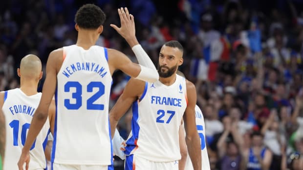 France power forward Victor Wembanyama embraces centre Rudy Gobert after the game against Brazil.