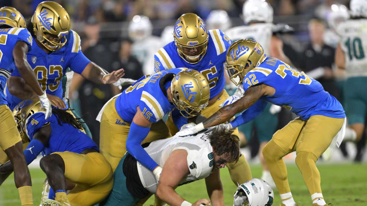 Sep 2, 2023; Pasadena, California, USA;    Coastal Carolina Chanticleers offensive lineman Will McDonald (66) loses his helmet as he is stopped by the UCLA Bruins offense after an interception in the second half at Rose Bowl. Mandatory Credit: Jayne Kamin-Oncea-USA TODAY Sports