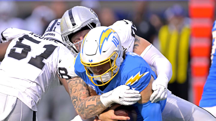 Oct 1, 2023; Inglewood, California, USA;  Los Angeles Chargers quarterback Justin Herbert (10) is sacked by Las Vegas Raiders defensive end Maxx Crosby (98) in the fourth quarter at SoFi Stadium. Mandatory Credit: Jayne Kamin-Oncea-Imagn Images