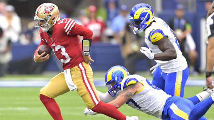 Sep 17, 2023; Inglewood, California, USA; San Francisco 49ers quarterback Brock Purdy (13) escapes the grip on Los Angeles Rams safety Quentin Lake (37) in the first half at SoFi Stadium. Mandatory Credit: Jayne Kamin-Oncea-Imagn Images