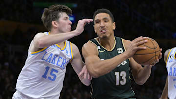 Dec 13, 2022; Los Angeles, California, USA;  Los Angeles Lakers guard Austin Reaves (15) defends Boston Celtics guard Malcolm Brogdon (13) as he moves to the basket in the first half at Crypto.com Arena. Mandatory Credit: Jayne Kamin-Oncea-Imagn Images