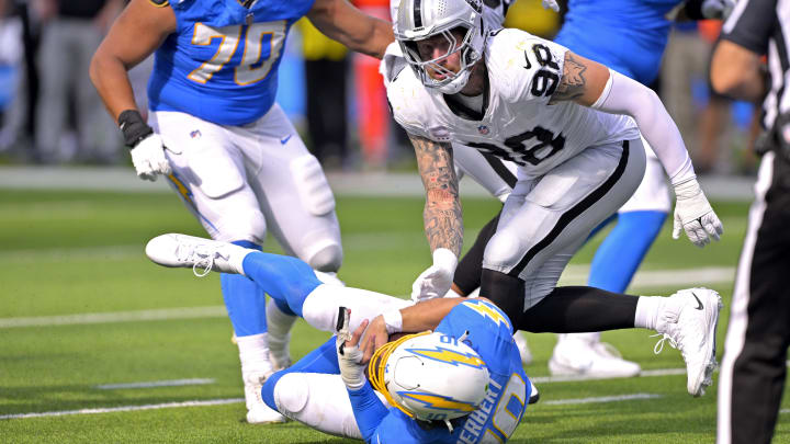 Oct 1, 2023; Inglewood, California, USA;  Los Angeles Chargers quarterback Justin Herbert (10) is sacked by Las Vegas Raiders defensive end Maxx Crosby (98) in the fourth quarter at SoFi Stadium. Mandatory Credit: Jayne Kamin-Oncea-USA TODAY Sports