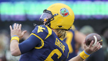 Nov 16, 2024; Morgantown, West Virginia, USA; The West Virginia National Guard logo is seen on the helmet of West Virginia Mountaineers quarterback Garrett Greene (6) during warmups prior to their game against the Baylor Bears at Mountaineer Field at Milan Puskar Stadium. Mandatory Credit: Ben Queen-Imagn Images