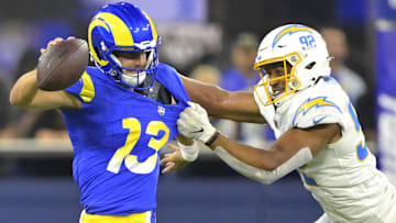 Aug 12, 2023; Inglewood, California, USA;   Los Angeles Rams quarterback Stetson Bennett (13) scrambles to break away from Los Angeles Chargers linebacker Andrew Farmer (92) in the second half at SoFi Stadium. Mandatory Credit: Jayne Kamin-Oncea-Imagn Images