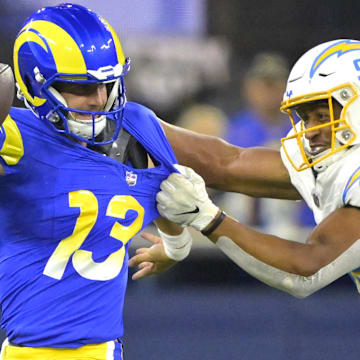 Aug 12, 2023; Inglewood, California, USA;   Los Angeles Rams quarterback Stetson Bennett (13) scrambles to break away from Los Angeles Chargers linebacker Andrew Farmer (92) in the second half at SoFi Stadium. Mandatory Credit: Jayne Kamin-Oncea-Imagn Images