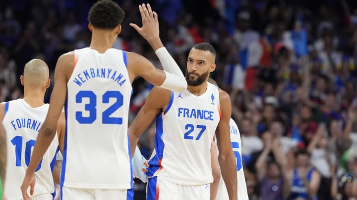 Jul 27, 2024; Villeneuve-d'Ascq, France; France power forward Victor Wembanyama (32) embraces centre Rudy Gobert (27) after the game against Brazil during the Paris 2024 Olympic Summer Games at Stade Pierre-Mauroy.