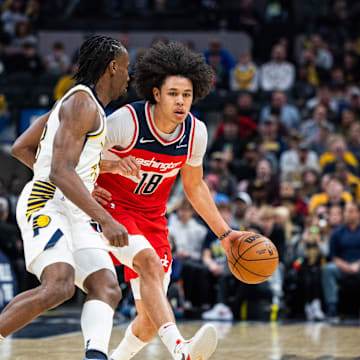 Apr 8, 2025; Indianapolis, Indiana, USA; Washington Wizards forward Kyshawn George (18) dribbles the ball while Indiana Pacers forward Aaron Nesmith (23) defends in the second half at Gainbridge Fieldhouse. Mandatory Credit: Trevor Ruszkowski-Imagn Images