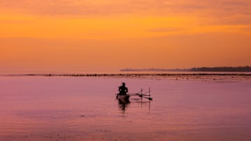 Man on a canoe on the sea, New Ireland Province, Kavieng, Papua New Guinea...