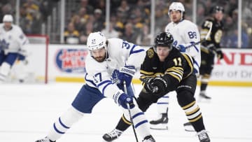 Apr 30, 2024; Boston, Massachusetts, USA; Toronto Maple Leafs defenseman Timothy Liljegren (37) reaches for the puck in front of Boston Bruins center Trent Frederic (11) during the first period in game five of the first round of the 2024 Stanley Cup Playoffs at TD Garden. Mandatory Credit: Bob DeChiara-USA TODAY Sports