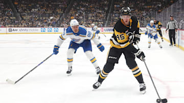 Oct 27, 2025; Pittsburgh, Pennsylvania, USA;  Pittsburgh Penguins defenseman Harrison Brunicke (45) handles the puck ahead of St. Louis Blues left wing Pavel Buchnevich (89) during the first period  at PPG Paints Arena. Mandatory Credit: Charles LeClaire-Imagn Images